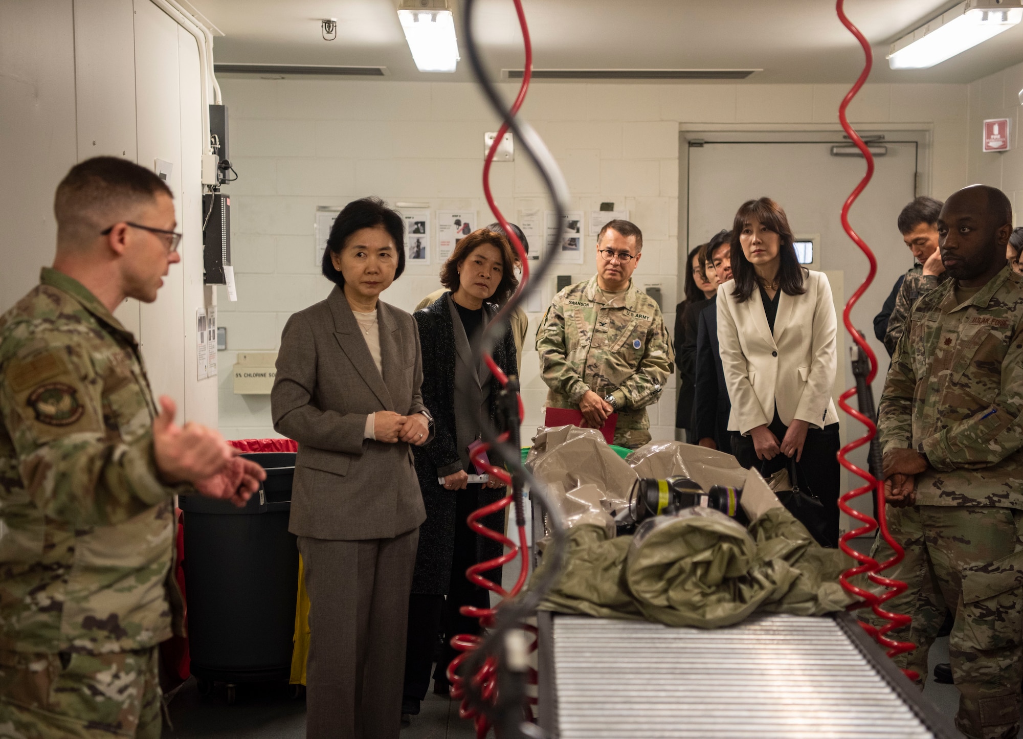 U.S. Air Force Maj. Romi Abouzedan, 51st Medical Group in-place patient decontamination team chief, left, briefs Dr. Young Mee Jee, Korea Disease Control Agency commissioner, center left, about the 51st MDG’s patient decontamination capabilities at Osan Air Base, Republic of Korea, April 3, 2025.