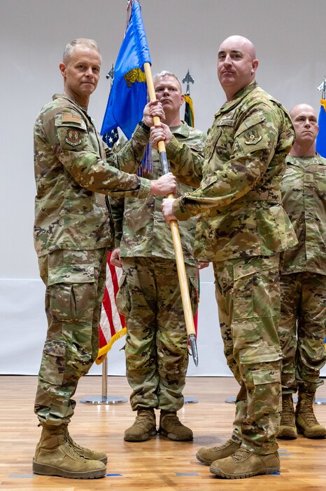 Lt. Gen. France stands left of frame presenting the guidon to Col. Kline who's standing right of frame in honor of the latter's relinquishment of command