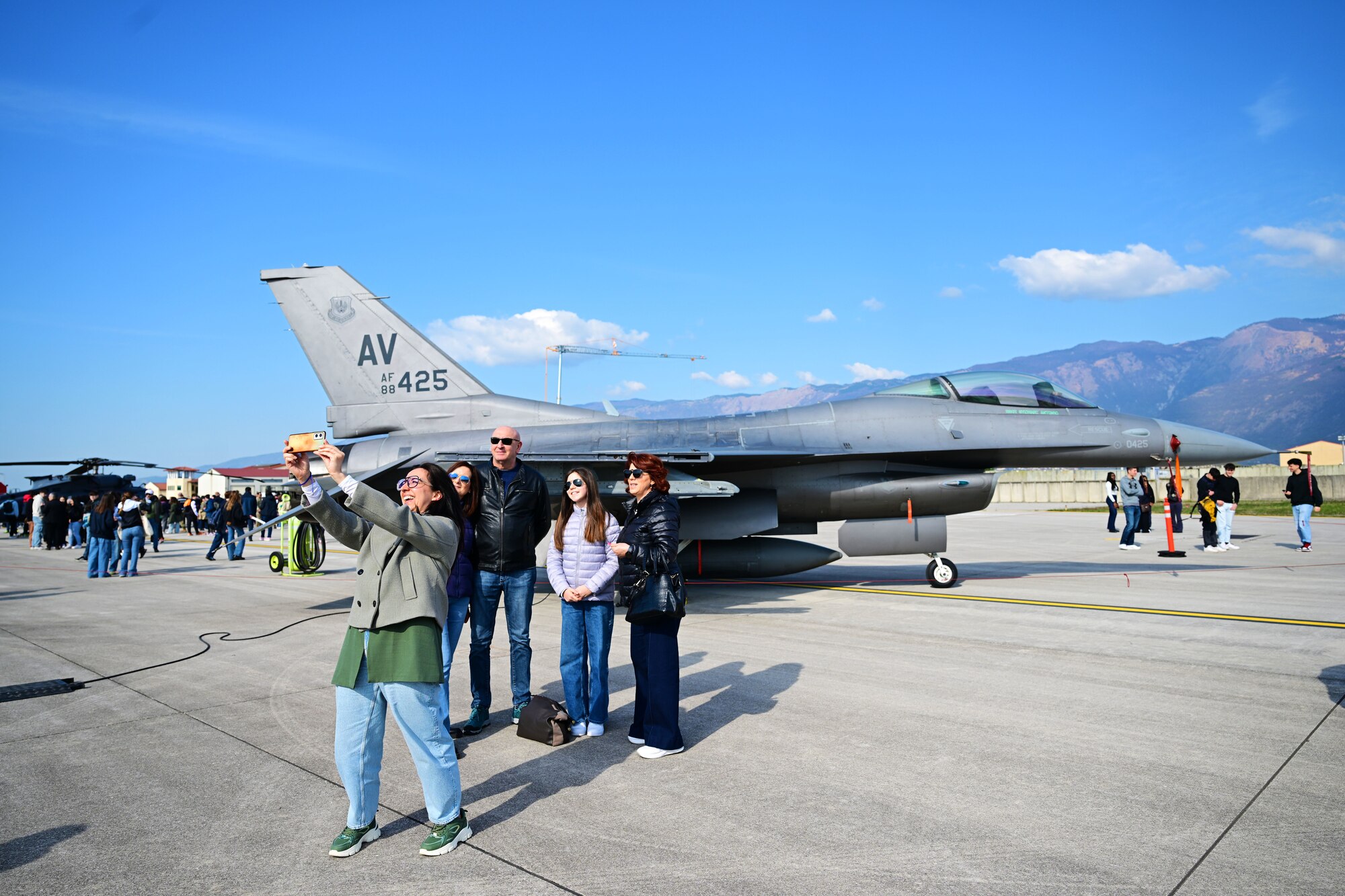 Visitors take a selfie in front of an F-16 Fighting Falcon static display.
