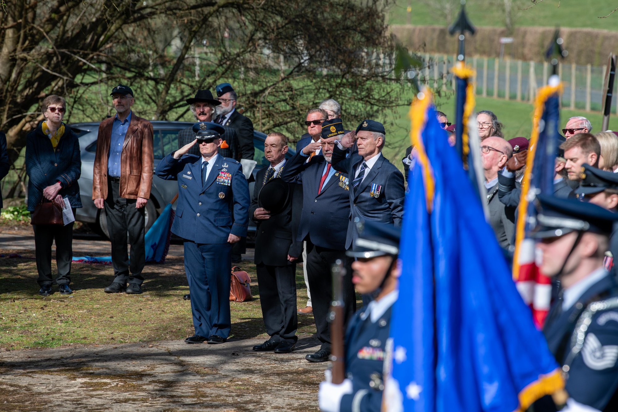 Members of the 501st Combat Support Wing and the local community render salutes during a memorial service