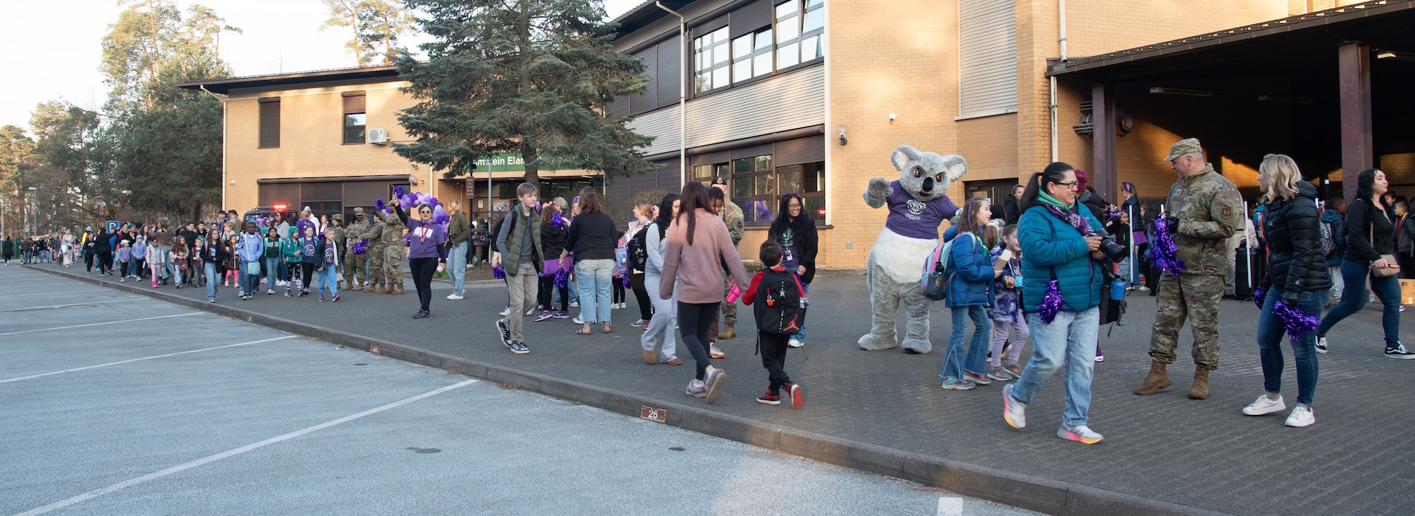 Members of the Kaiserslautern Military Community cheer on students from Ramstein Elementary School during a Purple Up! Day event at Ramstein Air Base, Germany, April 9, 2025.