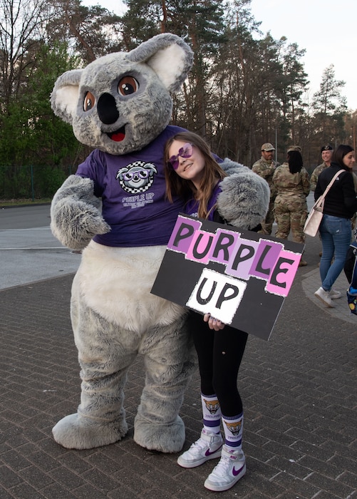 Kelly the Koala, Ramstein Elementary School’s mascot, poses for a photo with a Kaiserslautern Military Community student during the Purple Up! Day event at Ramstein Air Base, Germany, April 9, 2025.