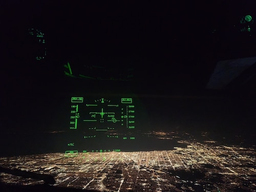 A heads-up display glows inside the cockpit of a U.S. Air Force C-17 Globemaster III aircraft assigned to the 6th Airlift Squadron during a nighttime approach over an undisclosed location, no date. Operating under the cover of darkness, 6th AS aircrews conducted global missions that demand precision, agility, and 24/7 readiness—core tenets of Air Mobility Command’s Rapid Global Mobility mission. (U.S. Air Force courtesy photo)