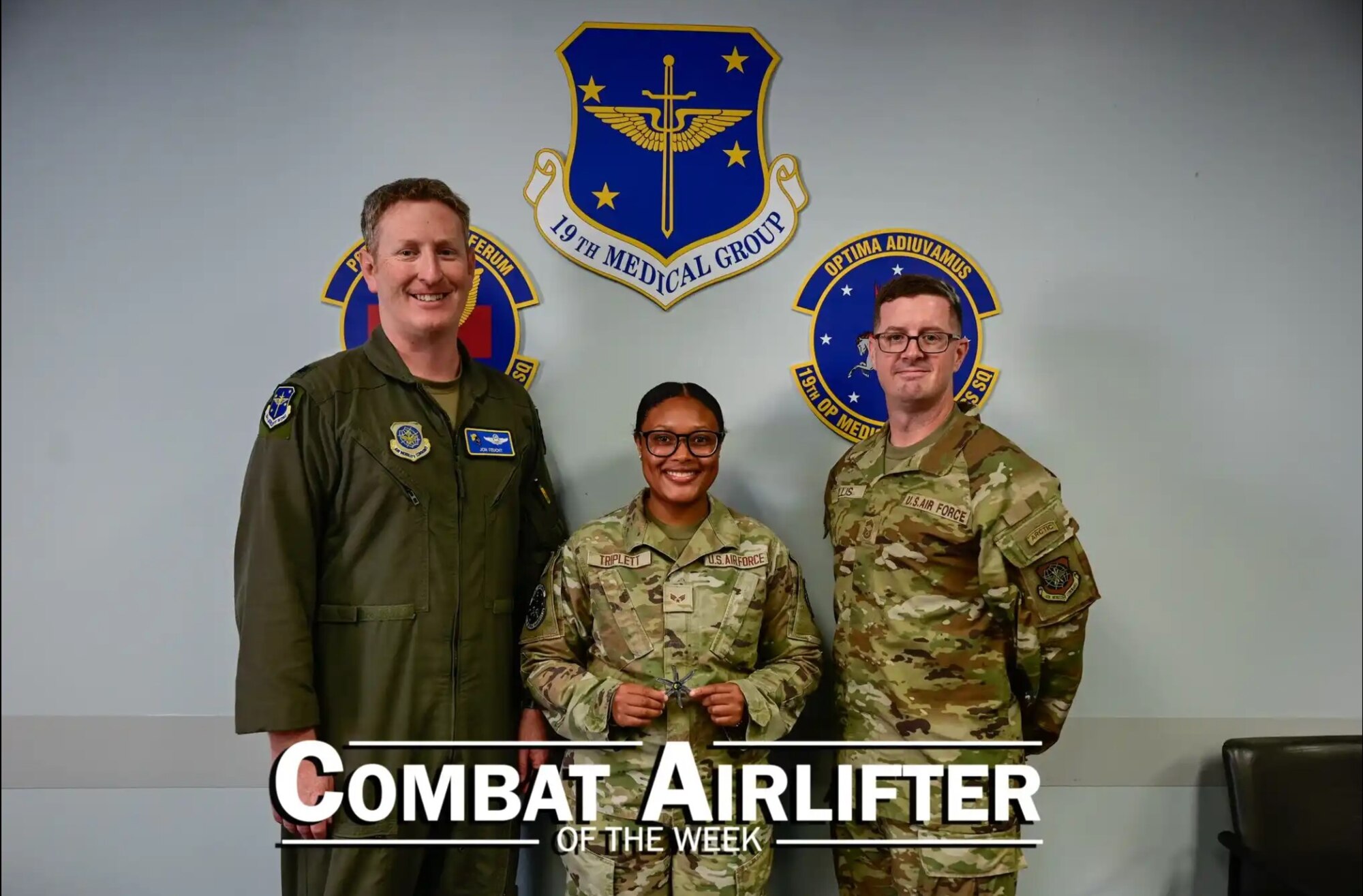 Woman and two men pose.