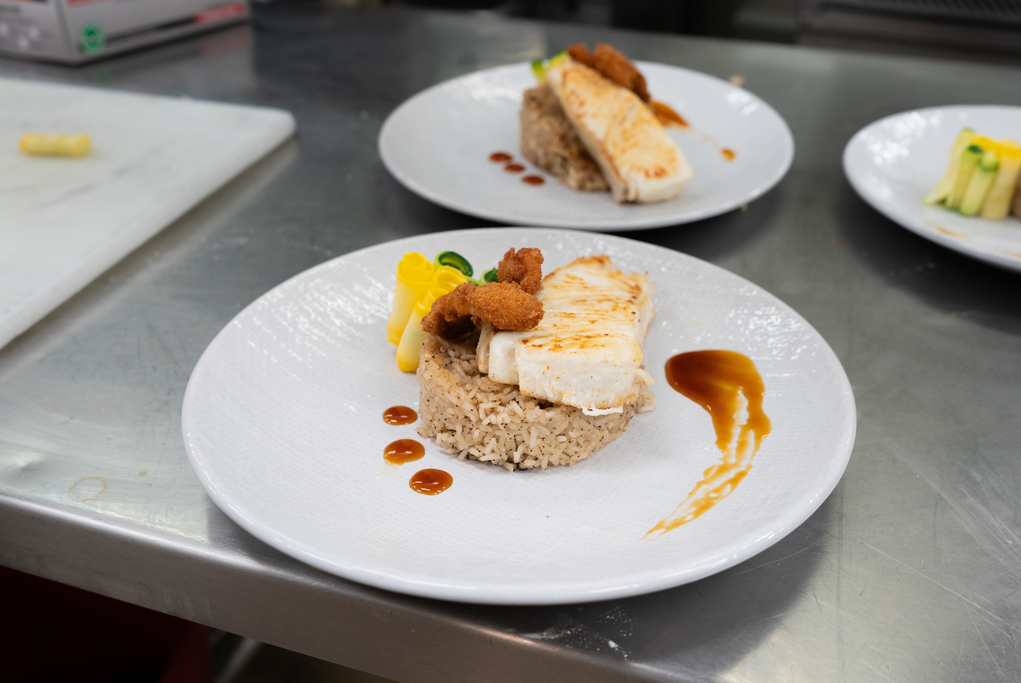 A meal featuring fish, fried squid, rice and vegetables is displayed during a cooking competition at the Wolves Den Warrior Restaurant on Fort Wainwright, Alaska, March 27, 2025.