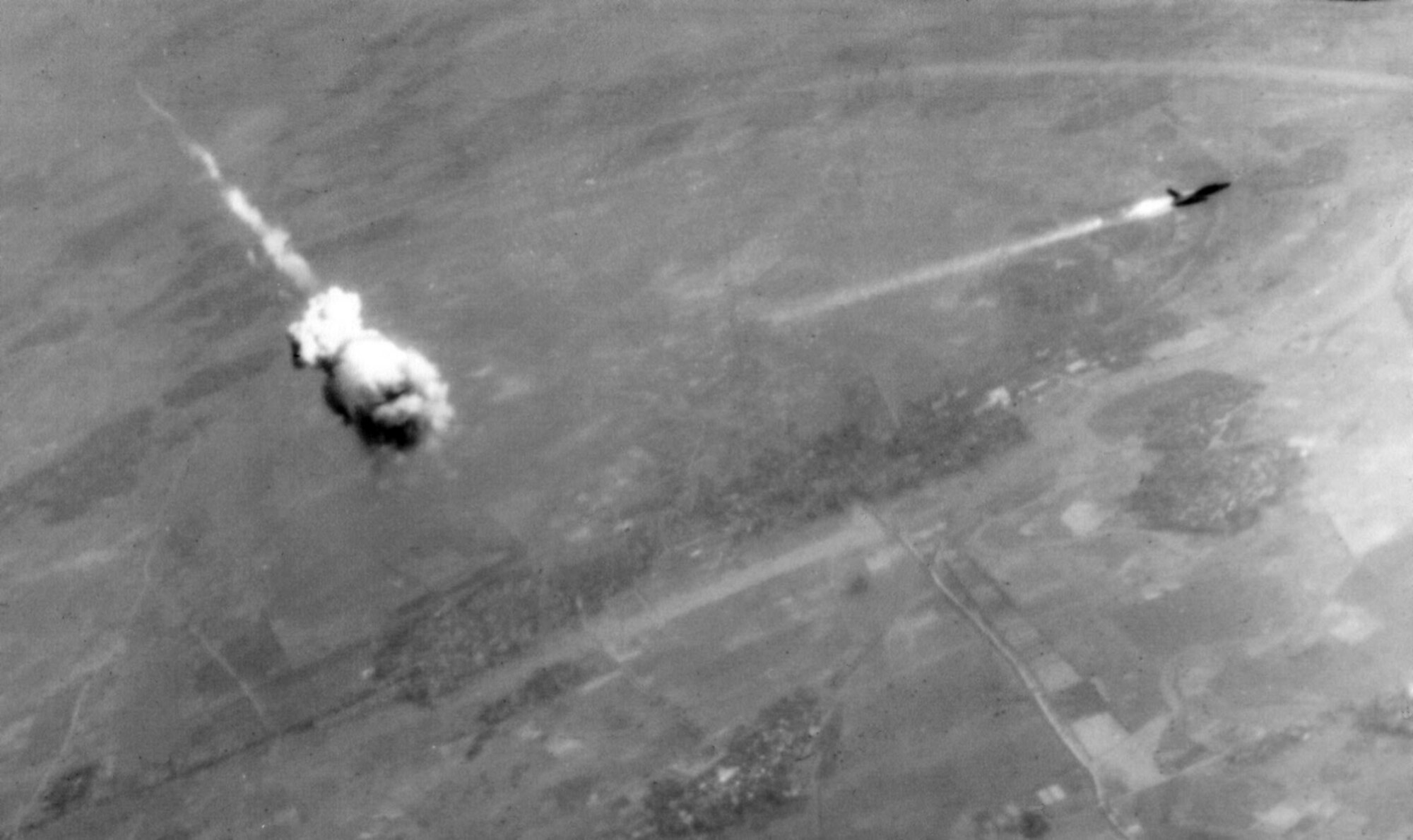 Colonel Edward B. Burdett, commander of the 388th Tactical Fighter Wing, was shot down by an SA-2 Guideline Surface-to-Air Missile (SAM) on November 18, 1967 during a Commando Club radar-assisted raid on Phuc Yen.  In a similar event a few months later, a USAF Republic F-105D-6-RE Thunderchief (serial no. 60-0418, of the 34th TFS, 388th TFW) trails fire and smoke just after interception by an SA-2 missile, about 12 miles south of Hanoi, North Vietnam on February 14, 1968. The SA-2 did not actually hit an aircraft - the warhead was detonated by a command from the tracking radar or by a proximity fuse in the missile when it neared the target, throwing deadly fragments over a wide area.  The pilot, Captain Robert Malcolm Elliot (1929-1968), was initially listed as MIA after other USAF personnel observed a possible parachute.  He was declared dead in 1979.  In 1988 the Vietnamese returned his ID card and a small, partial set of remains which were inadequate to confirm identity.  Capt. Elliot died from injuries, according to the Vietnamese in a document they released in 1992.  Col Elliot’s remains (he was promoted during his time carried as MIA) were not recovered until 1998, identity then confirmed, and were buried at Arlington National Cemetery in 1990.  (National Museum of the USAF, via Wikipedia)