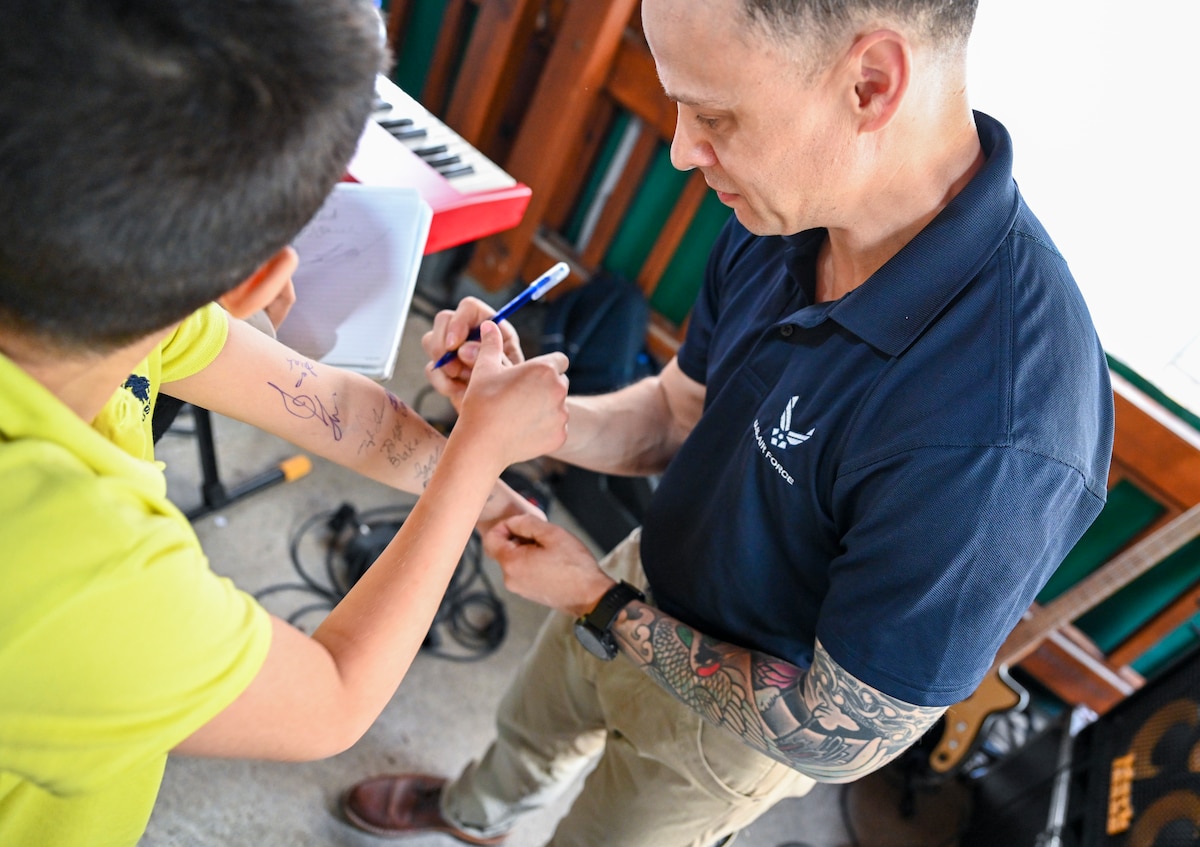 U.S. Air Force Staff Sgt. Lancer Hardy, bassist with the U.S. Air Forces in Europe and Air Forces Africa Band’s “Touch N’ Go” ensemble, signs autographs for students after a performance at the Turkish American Association in Adana, Türkiye, April 6, 2025. The event welcomed more than 300 students studying English and American culture, offering a unique opportunity for cultural exchange and personal connection. The performance was part of a weeklong tour supporting the city’s annual Orange Blossom Carnaval. (U.S. Air Force photo by Master Sgt. Siuta Ika)