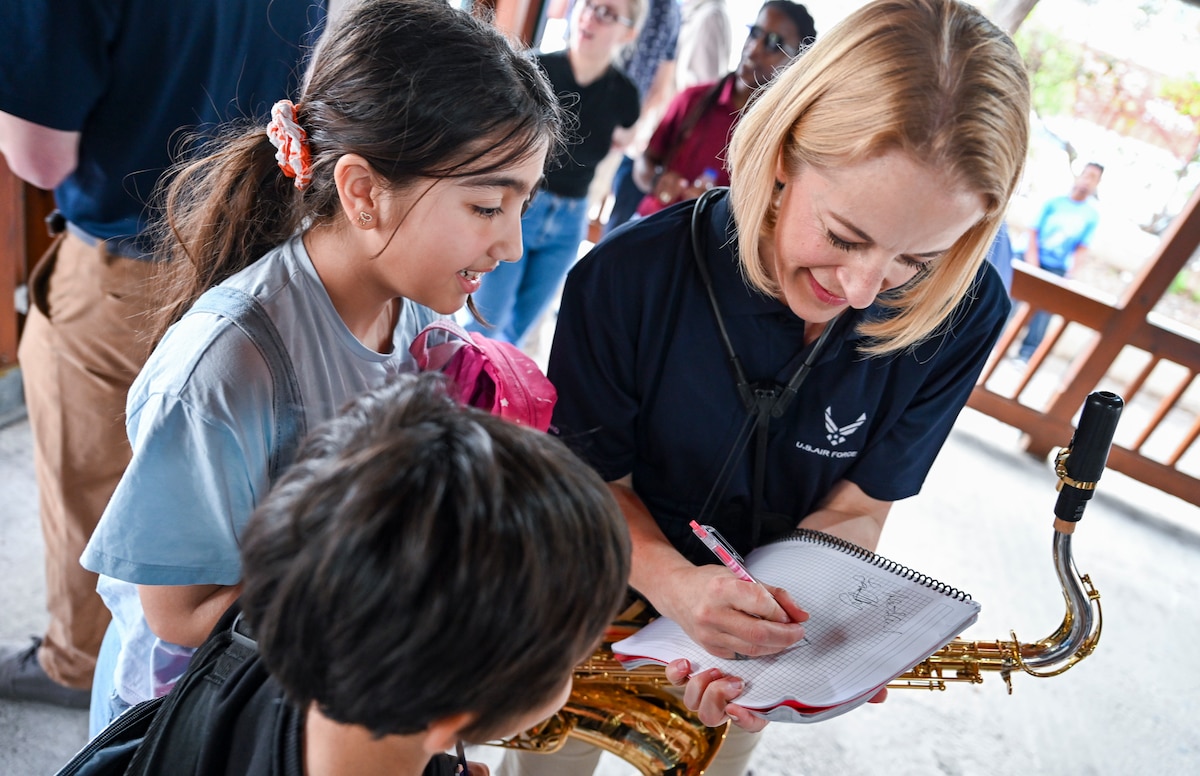 U.S. Air Force Staff Sgt. Sarah Cosano, saxophonist with the U.S. Air Forces in Europe and Air Forces Africa Band’s “Touch N’ Go” ensemble, signs autographs and chats with students after a performance at the Turkish American Association in Adana, Türkiye, April 6, 2025. The post-show interaction was part of a broader effort to foster cultural exchange and connect with students studying English and American culture. The performance was one of several during a weeklong tour supporting the city’s annual Orange Blossom Carnaval. (U.S. Air Force photo by Master Sgt. Siuta Ika)