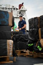 A crew member from Coast Guard Cutter James assists in offloading illegal narcotics in Port Everglades, April 9, 2025. James’ crew offloaded more than 44,550 pounds of cocaine and 3,880 pounds of marijuana valued at approximately $509.9 million intercepted in the international waters of the Eastern Pacific Ocean. (Coast Guard photo by Petty Officer 3rd Class Jessica Walker)