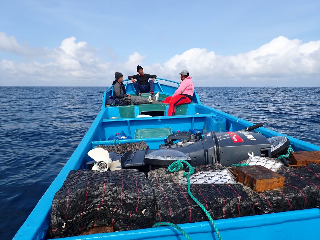 Suspected drug smugglers sit at the front of their vessel in the Eastern Pacific Ocean, Jan 6. 2025. The crew of U.S. Coast Guard Cutter James offloaded more than 44,550 pounds of cocaine and 3,880 pounds of marijuana valued at approximately $509.9 million in Port Everglades, April 9, 2025. (U.S. Coast Guard photo)