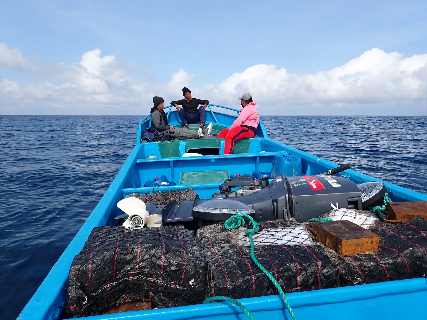 Suspected drug smugglers sit at the front of their vessel in the Eastern Pacific Ocean, Jan 6. 2025. The crew of U.S. Coast Guard Cutter James offloaded more than 44,550 pounds of cocaine and 3,880 pounds of marijuana valued at approximately $509.9 million in Port Everglades, April 9, 2025. (U.S. Coast Guard photo)