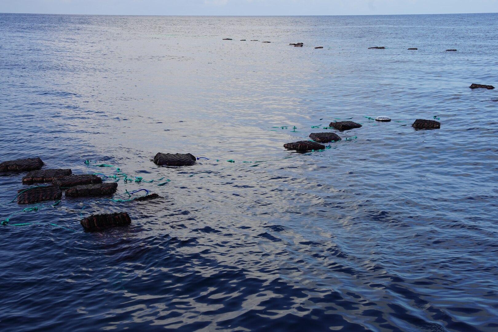 Jettisoned bales of illegal narcotics float in the Eastern Pacific Ocean, Jan. 6, 2025. The crew of U.S. Coast Guard Cutter James offloaded more than 44,550 pounds of cocaine and 3,880 pounds of marijuana valued at approximately $509.9 million in Port Everglades, April 9, 2025. (U.S. Coast Guard photo)