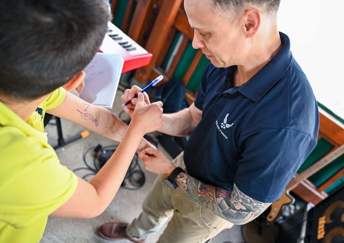U.S. Air Force Staff Sgt. Lancer Hardy, bassist with the U.S. Air Forces in Europe and Air Forces Africa Band’s “Touch N’ Go” ensemble, signs autographs for students after a performance at the Turkish American Association in Adana, Türkiye, April 6, 2025. The event welcomed more than 300 students studying English and American culture, offering a unique opportunity for cultural exchange and personal connection. The performance was part of a weeklong tour supporting the city’s annual Orange Blossom Carnaval. (U.S. Air Force photo by Master Sgt. Siuta Ika)