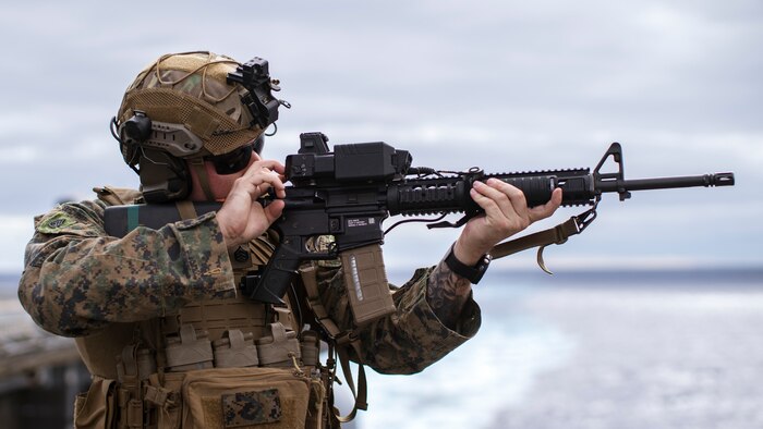 U.S. Marine Corps Staff Sgt. Richard Ashby, a low altitude air defense gunner assigned to Marine Medium Tiltrotor Squadron (VMM) 165 (Reinforced), 15th Marine Expeditionary Unit, and a native of Michigan, sights in with a fire control  sight system attached to an M16 rifle during a counter-unmanned aircraft system drill aboard the amphibious assault ship USS Boxer (LHD 4) in the Pacific Ocean July 20, 2024. Elements of the 15th MEU are currently embarked aboard the Boxer Amphibious Ready Group conducting routine operations in U.S. 3rd Fleet. (U.S. Marine Corps photo by Cpl. Amelia Kang)