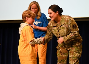 U.S. Air Force Lt. Col. Nancy Scwab, 17th Training Support Squadron commander, shakes hands with a participant during the Fourth Annual Youth Cybersecurity Workshop and Expo at Houston Harte University Center, Angelo State University, San Angelo, Texas, April 4, 2025. Students across San Angelo Independent School District attended the event to get insight into the cybersecurity career field and learn about safe internet habits. (U.S. Air Force photo by Senior Airman Evelyn J. D’Errico)