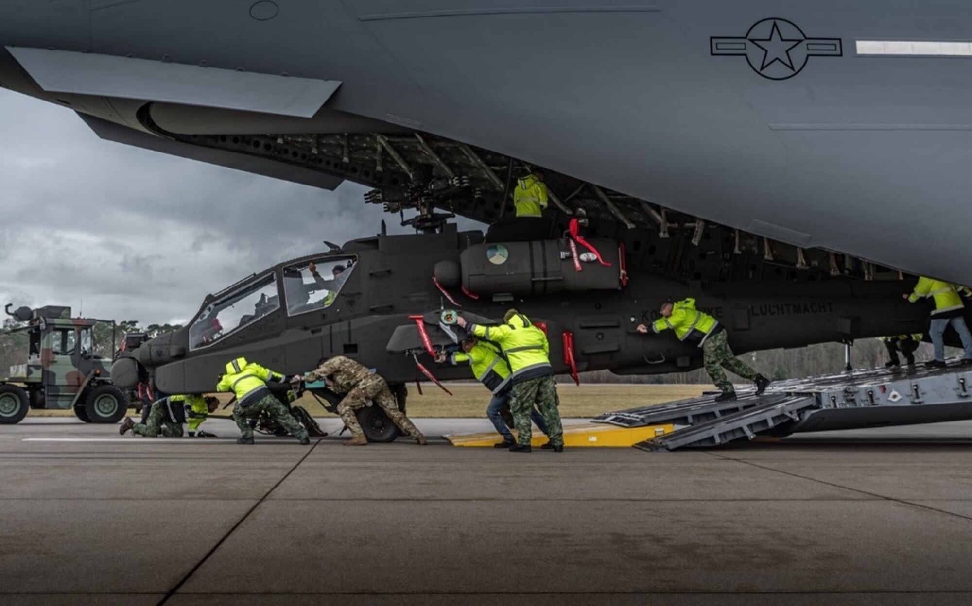 U.S. Air Force loadmasters assigned to the 6th Airlift Squadron offload an AH-64 Apache helicopter assigned to the Royal Netherlands Air Force from a C-17 Globemaster III aircraft at an undisclosed location, no date. The mission was part of a broader effort supporting combatant command requirements around the globe, reflecting the 6th AS’s ability to rapidly deliver combat ready assets. These operations reinforce the squadron’s vital role in providing maneuver and sustainment for the Joint Force. (Royal Netherlands Air Force courtesy photo)