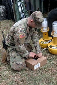 U.S. Army Spc. Dave Thomson, a public affairs specialist with the 109th Mobile Public Affairs Detachment, 213th Regional Support Group, sets up equipment for a field training exercise at Fort Indiantown Gap, Pennsylvania, April 4, 2024. These Soldiers executed the FTX, which included running a media operations center in a combat scenario, to improve the unit's readiness for future missions. (U.S. Army National Guard photo by Spc. Skylin Simpson)