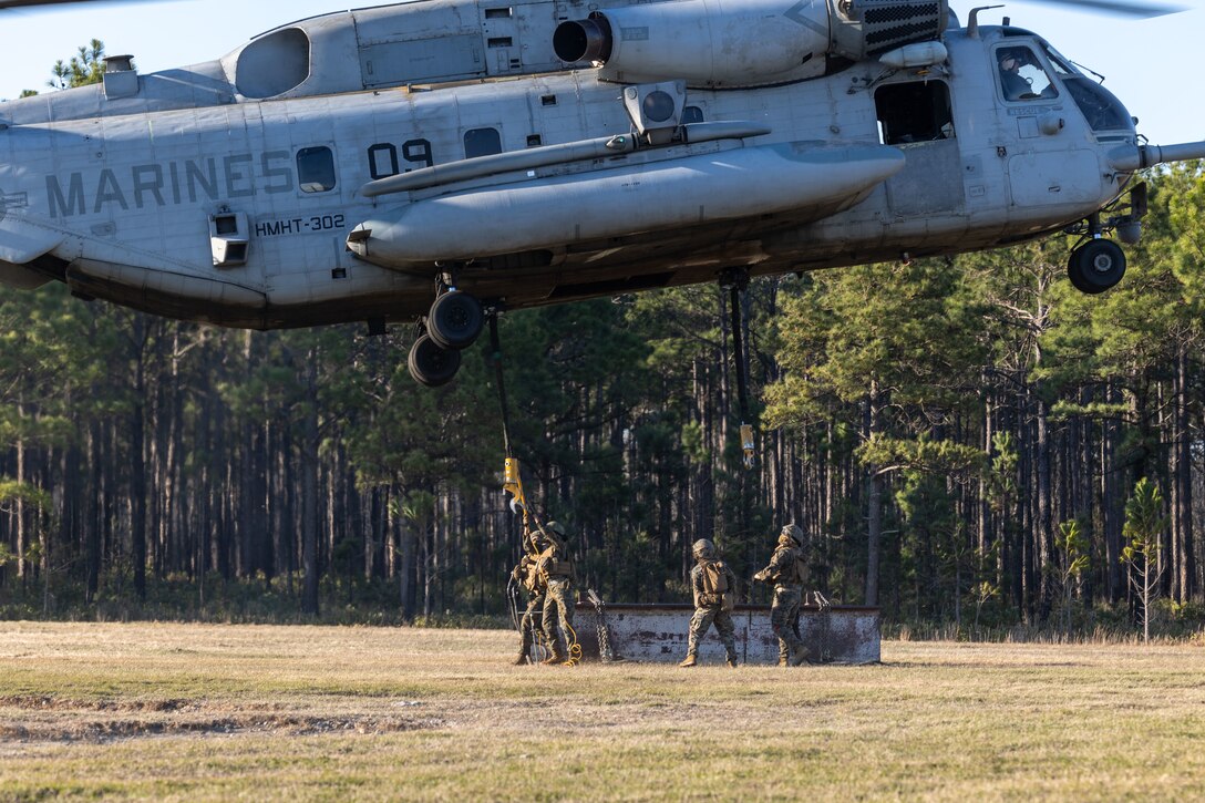 U.S. Marines with Combat Logistics Battalion 25, 4th Marine Logistics Group, work to attach an H Beam onto a CH-53E Super Stallion assigned to Marine Heavy Helicopter Training Squadron 302 (HMHT-302), Marine Aircraft Group 29 (MAG-29), 2nd Marine Aircraft Wing (2nd MAW), during a helicopter support team training at Camp Lejeune, North Carolina, Mar. 27, 2025. Landing support specialists and pilots conducted HST to familiarize themselves with insertions and extractions of heavy loads to increase their proficiency in combat scenarios. (U.S. Marine Corps photo by Cpl. Salvador Flores Perez)