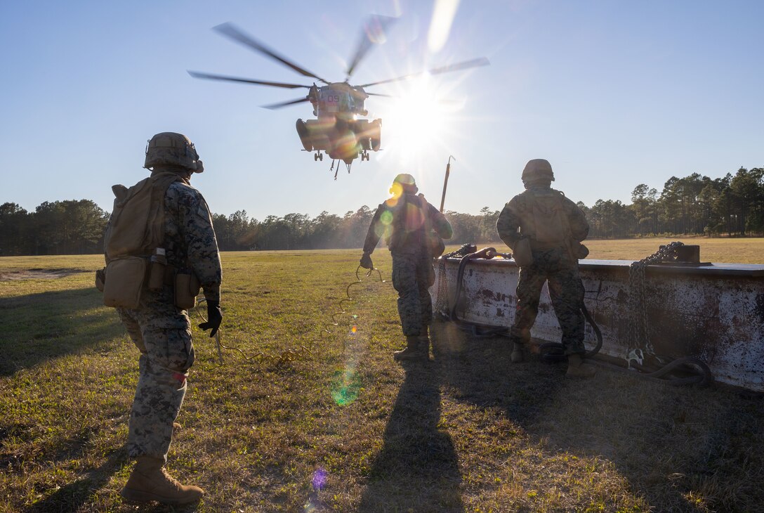 U.S. Marines with Combat Logistics Battalion 25, 4th Marine Logistics Group, await an approaching CH-53E Super Stallion assigned to Marine Heavy Helicopter Training Squadron 302 (HMHT-302), Marine Aircraft Group 29 (MAG-29), 2nd Marine Aircraft Wing (2nd MAW), during a helicopter support team training at Camp Lejeune, North Carolina, Mar. 27, 2025. Landing support specialists and pilots conducted HST to familiarize themselves with insertions and extractions of heavy loads to increase their proficiency in combat scenarios. (U.S. Marine Corps photo by Cpl. Salvador Flores Perez)
