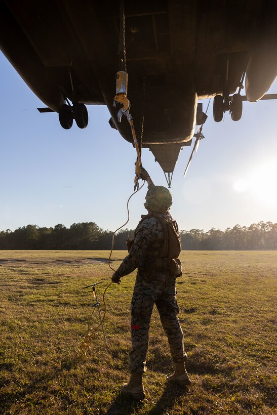 U.S. Marine Corps Cpl. Noah J. McGhee, landing support team leader with Combat Logistics Battalion 25, 4th Marine Logistics Group, discharges a cargo cable with a grounding hook from a CH-53E Super Stallion assigned to Marine Heavy Helicopter Training Squadron 302 (HMHT-302), Marine Aircraft Group 29 (MAG-29), 2nd Marine Aircraft Wing (2nd MAW), during Helicopter Support Team training at Camp Lejeune, North Carolina, Mar. 27, 2025. Landing support specialists and pilots conducted HST to familiarize themselves with insertions and extractions of heavy loads to increase their proficiency in combat scenarios. (U.S. Marine Corps photo by Cpl. Salvador Flores Perez)
