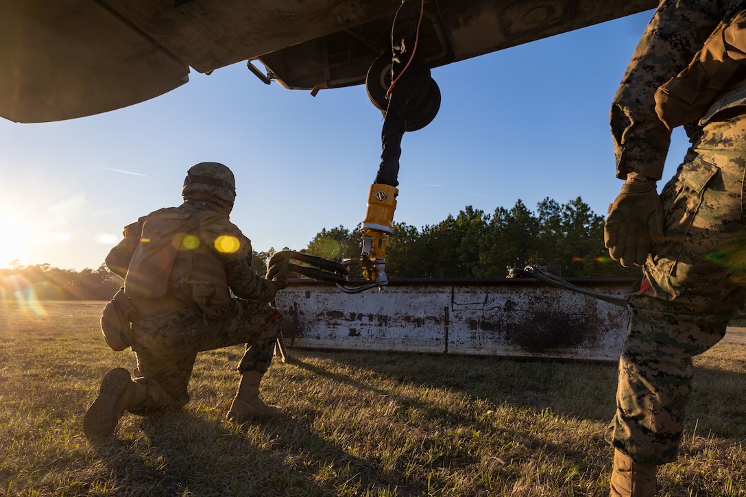 U.S. Marine Corps Lance Cpl. Refugio Estrella, landing support specialist, with Combat Logistics Battalion 25, 4th Marine Logistics Group, hooks an H Beam onto a CH-53K King Stallion assigned to Marine Heavy Helicopter Squadron 461 (HMH-461), Marine Aircraft Group 29 (MAG-29), 2nd Marine Aircraft Wing (2nd MAW), during a helicopter support team training at Camp Lejeune, North Carolina, Mar. 27, 2025. Landing support specialists and pilots conducted HST to familiarize themselves with insertions and extractions of heavy loads to increase their proficiency in combat scenarios. (U.S. Marine Corps photo by Cpl. Salvador Flores Perez)