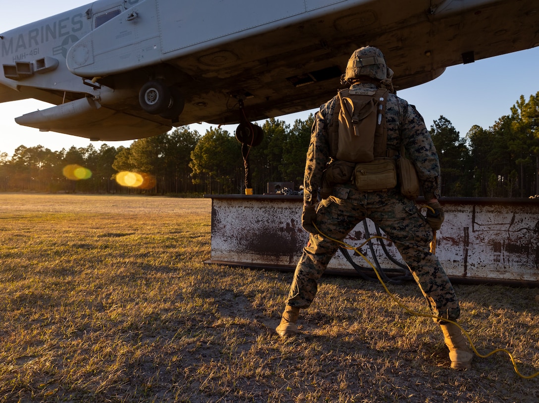 U.S. Marine Corps Cpl. Noah J. McGhee, landing support team leader with Combat Logistics Battalion 25, 4th Marine Logistics Group, observes as an CH-53K King Stallion assigned to Marine Heavy Helicopter Squadron 461 (HMH-461), Marine Aircraft Group 29 (MAG-29), 2nd Marine Aircraft Wing (2nd MAW), hovers over an H Beam at Camp Lejeune, North Carolina, Mar. 27, 2025. Landing support specialists and pilots conducted HST to familiarize themselves with insertions and extractions of heavy loads to increase their proficiency in combat scenarios. (U.S. Marine Corps photo by Cpl. Salvador Flores Perez)