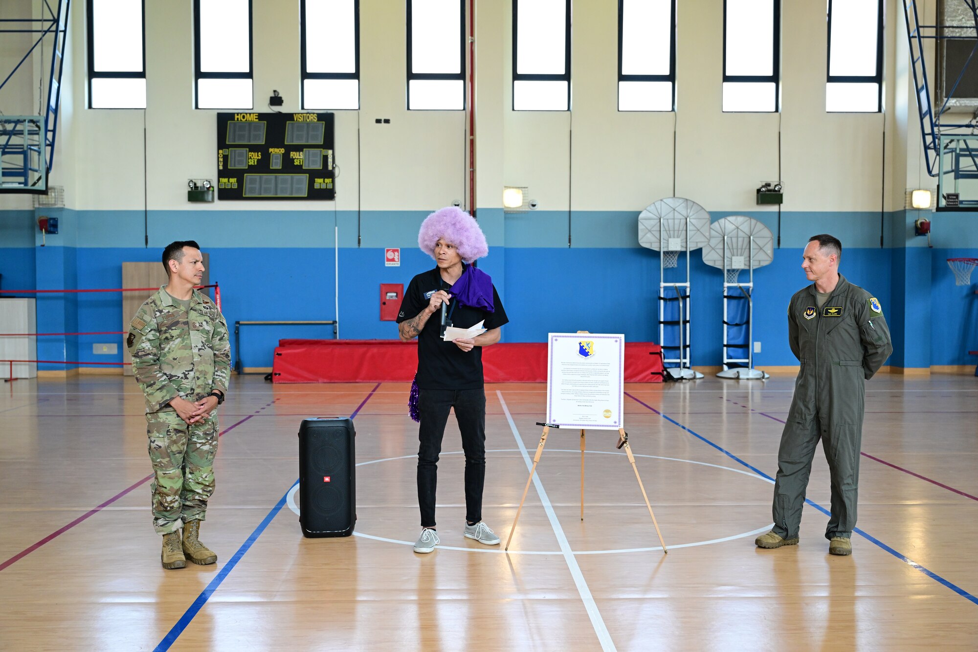 Aviano Young Program manager talks into a microphone to the students.