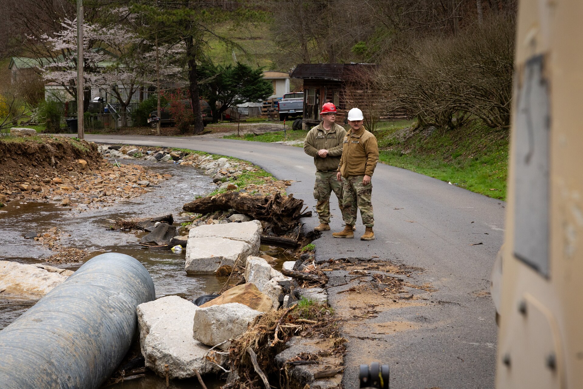 U.S. Army Spc. Devon Middleton and Sgt. Brian Mccall surveys flood damage on a county road in Hindman, Ky. on April 1, 2025. Middleton and Maccall and members of Detachment 1, 149th Vertical Construction Company, 149th Maneuver Enhancement Brigade have been working for over a month to help counties repair critical roads since flooding in February. (U.S. Army National Guard photo by Andy Dickson)