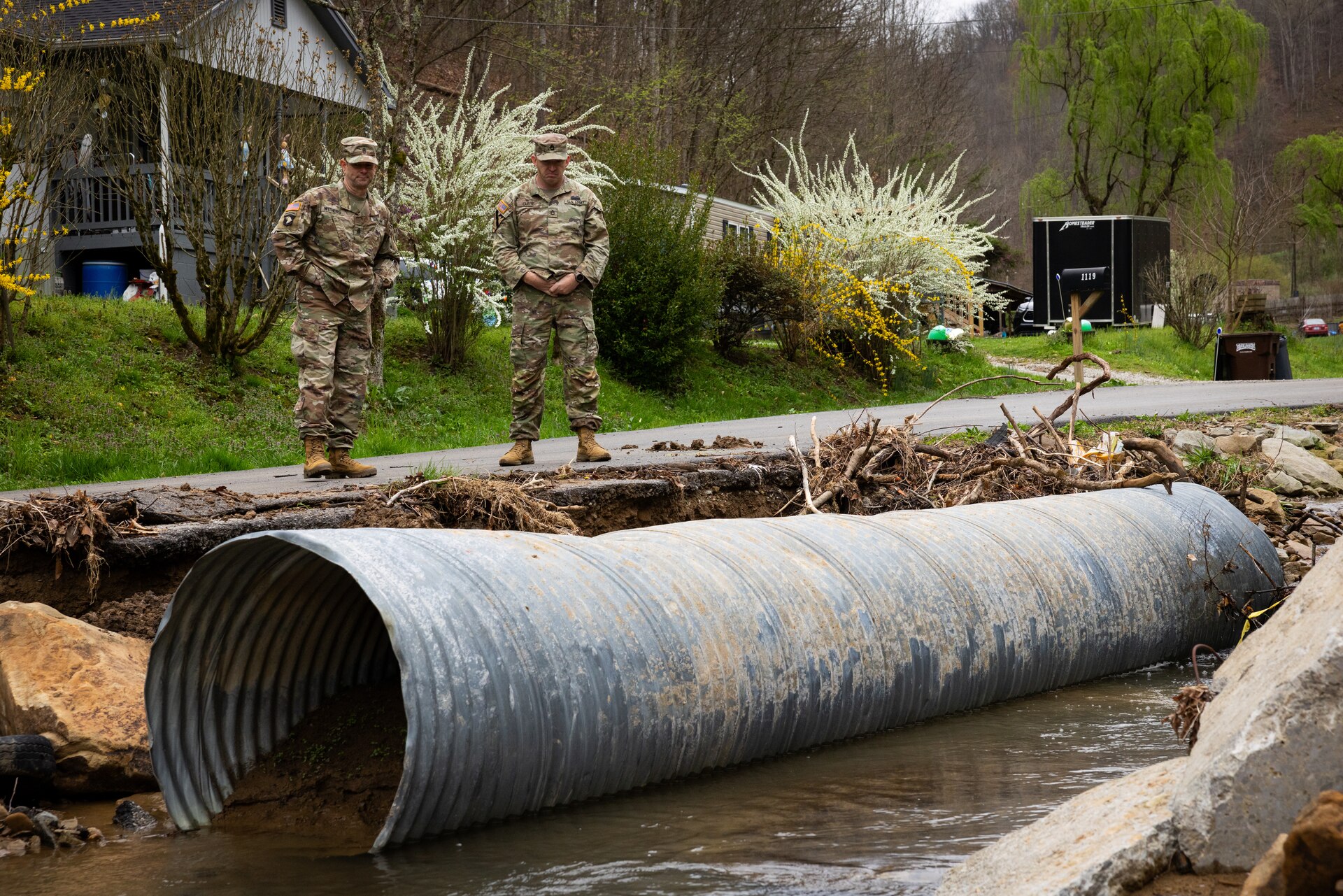 U.S. Army Command Sgt. Maj. Jesse Withers, Kentucky Army National Guard senior enlisted advisor, and Sgt. 1st Class Ron Clere surveys damage on a county road in Hindman, Ky. on April 1, 2025. Clere and members of Detachment 1, 149th Vertical Construction Company, 149th Maneuver Enhancement Brigade have been working for over a month to help counties repair critical roads since flooding in February. (U.S. Army National Guard photo by Andy Dickson)