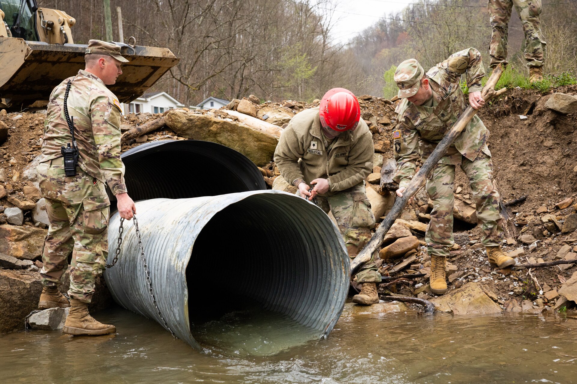 U.S. Army Command Sgt. Maj. Jesse Withers, Kentucky Army National Guard senior enlisted advisor, and Staff Sgt. Micheal Holtgraver, and Spc. Devon Middleton ties up a culvert pipe on a county road in Hindman, Ky. on April 1, 2025. Holtgraver, Middleton, and members of Detachment 1, 149th Vertical Construction Company, 149th Maneuver Enhancement Brigade have been working for over a month to help counties repair critical roads since flooding in February. (U.S. Army National Guard photo by Andy Dickson)