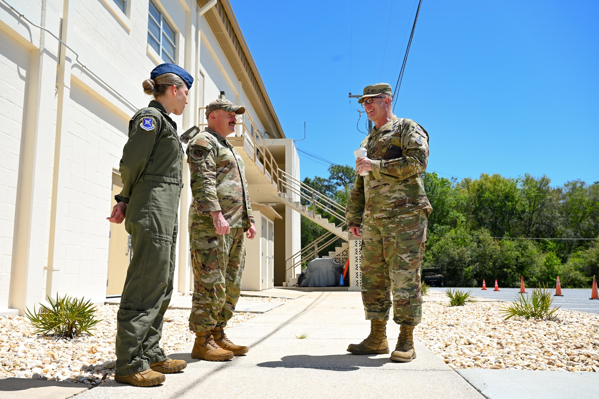 U.S. Air Force Col. Candice Sperry, 350th Spectrum Warfare Group commander, left, and U.S. Air Force Chief Master Sgt. Will Cupp, 350th Spectrum Warfare Wing command chief, middle, talk with U.S. Space Force Maj. Gen. Timothy Sejba, Space Training and Readiness Command commander, right, at the start of a visit to the 350th Spectrum Warfare Wing at Eglin Air Force Base, Florida, April 8, 2025. The visit offered an opportunity to discuss the missions of the 350 SWW and STARCOM and shared mission equities between both units. (U.S. Air Force photo by Capt. Benjamin Aronson)