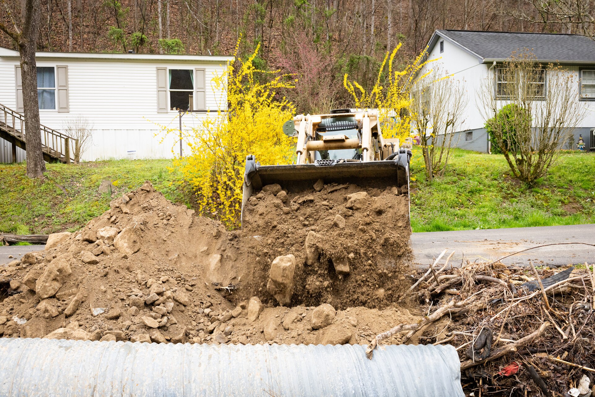 U.S. Army Sgt. Brian Mccall uses a skid steer to repair roadsides on a county road in Hindman, Ky. on April 1, 2025. Maccall and members of Detachment 1, 149th Vertical Construction Company, 149th Maneuver Enhancement Brigade have been working for over a month to help counties repair critical roads since flooding in February. (U.S. Army National Guard photo by Andy Dickson)