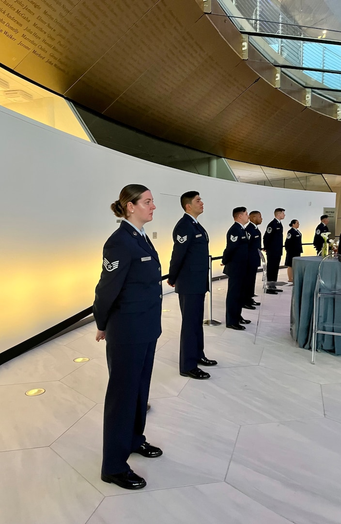 A group of male and female airmen dressed in blue at parade rest