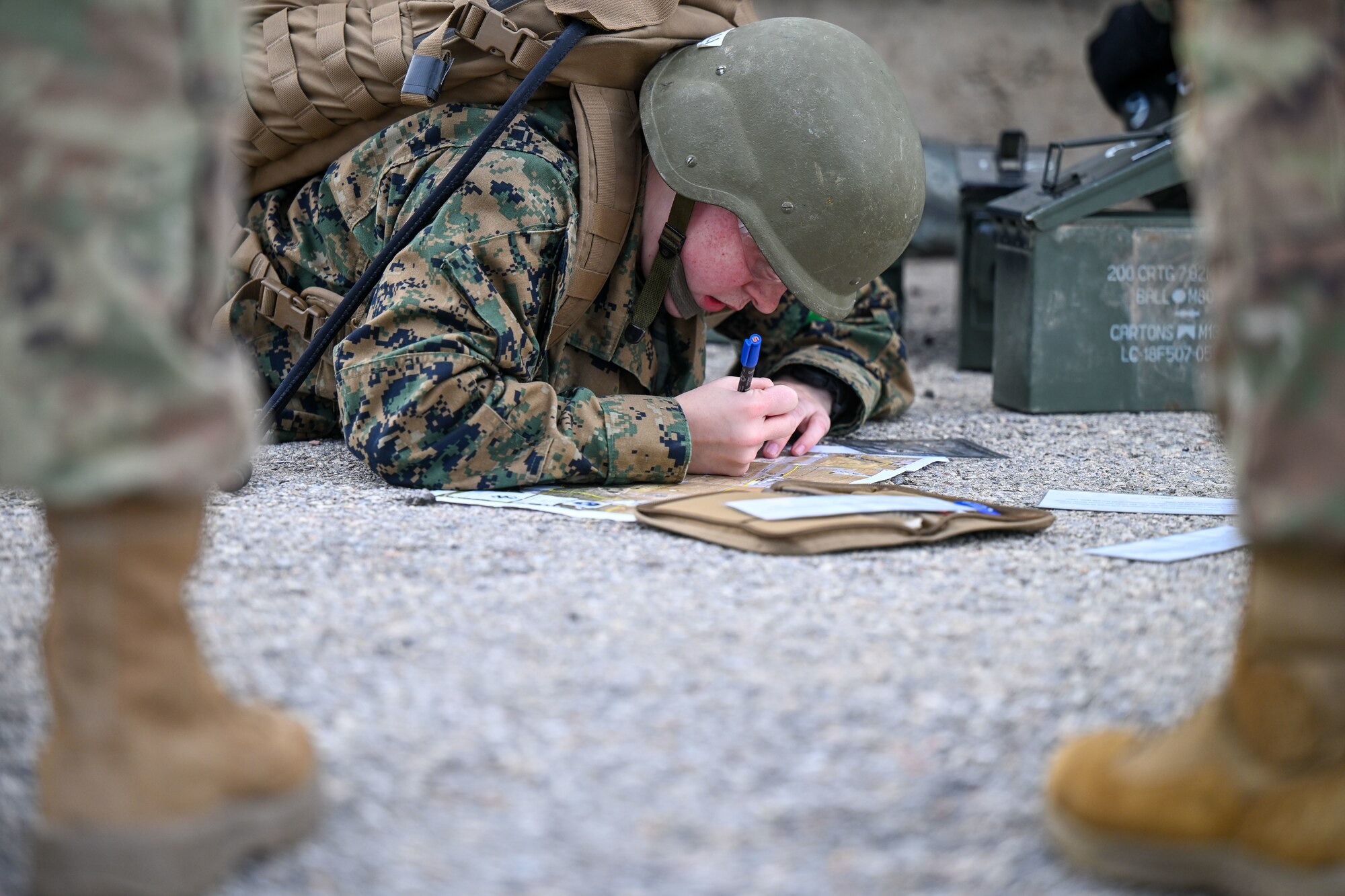 ROTC student laying on ground with a map charting coordinates