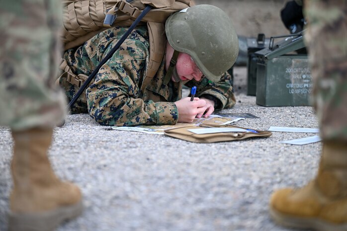 ROTC student laying on ground with a map charting coordinates