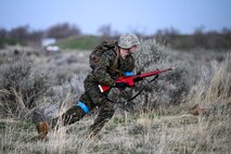 A ROTC student runs to take cover in a field