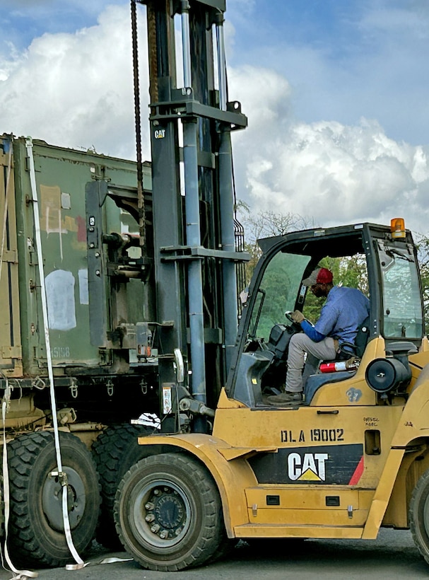 A man on a forklift moves materials.