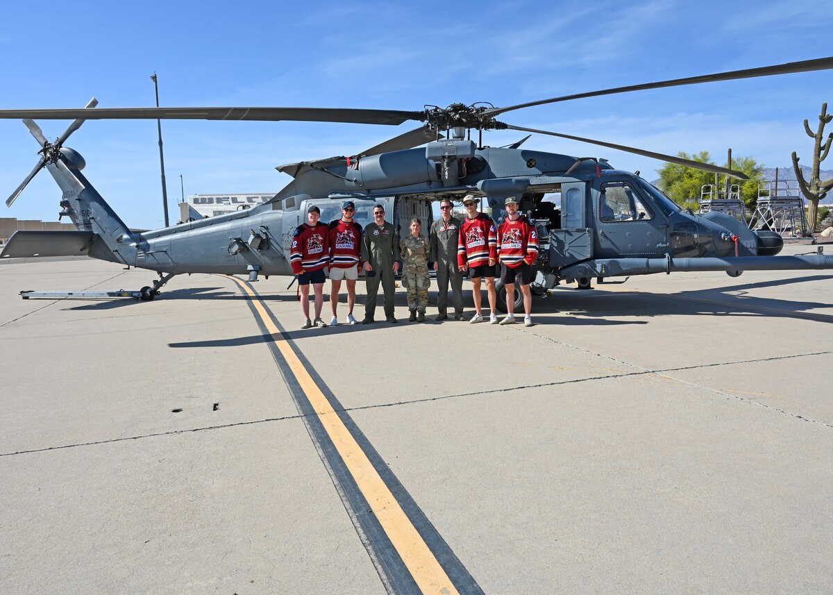 U.S. Airmen assigned to the 55th Rescue Squadron pose with members of Tucson Roadrunners, a local minor league hockey team, at Davis-Monthan Air Force Base, Arizona, April 8, 2025. The 355th Wing provided a base tour to establish and maintain positive relationships with the community. (U.S. Air Force photo by Staff Sgt. Abbey Rieves)
