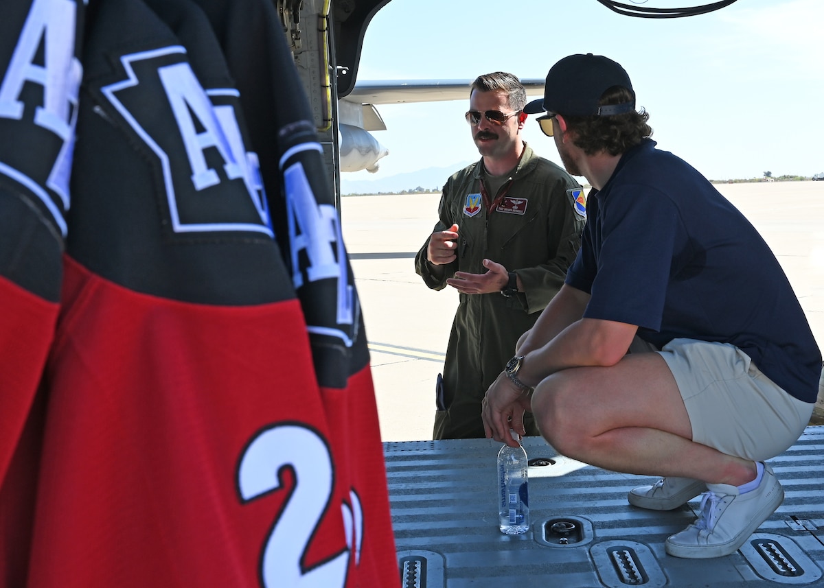 U.S. Air Force Tech. Sgt. Hayden Reynolds, 55th Rescue Squadron special missions aviator, talks with a member of the Tucson Roadrunners, a local minor league hockey team, about the capabilities of the HH-60W Jolly Green II helicopter at Davis-Monthan Air Force Base, Arizona, April 8, 2025. Reynolds spoke of his job and his personal military experiences and answered questions about daily life in the military and DM’s mission. (U.S. Air Force photo by Staff Sgt. Abbey Rieves)