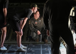 U.S. Air Force Staff Sgt. Ryan Murphy, 79th Rescue Squadron instructor loadmaster, center, briefs members of Tucson Roadrunners, a local minor league hockey team, about the capabilities of the HC-130J Combat King II aircraft at Davis-Monthan Air Force Base, Arizona, April 8, 2025. The 355th Wing values a strong community partnership as a way to generate greater local support and understanding for the Wing’s initiatives and services. (U.S. Air Force photo by Staff Sgt. Abbey Rieves)