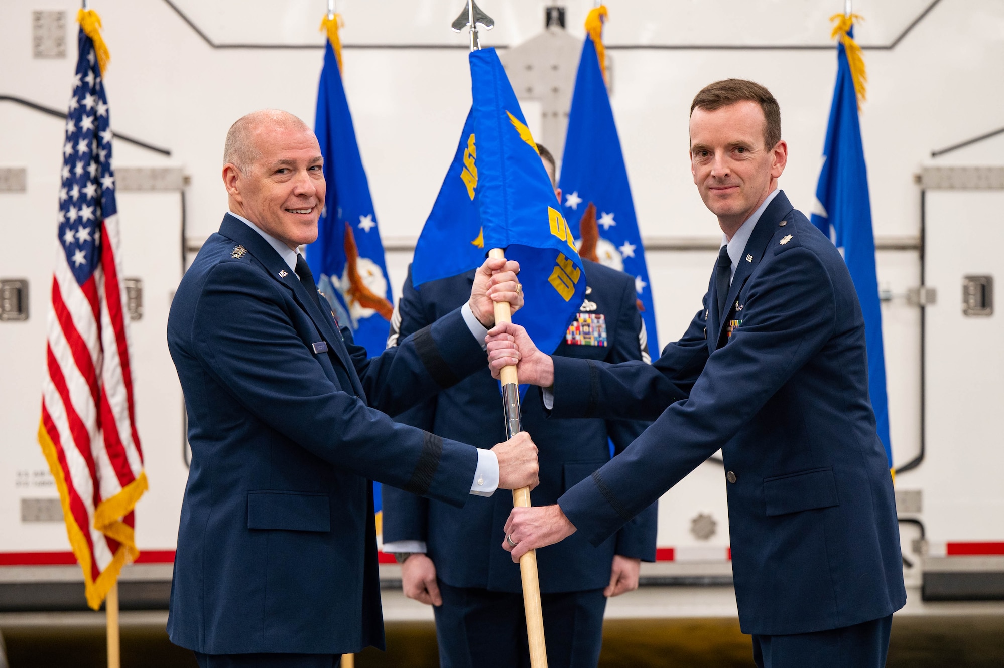 Men in uniform conduct a ceremony.