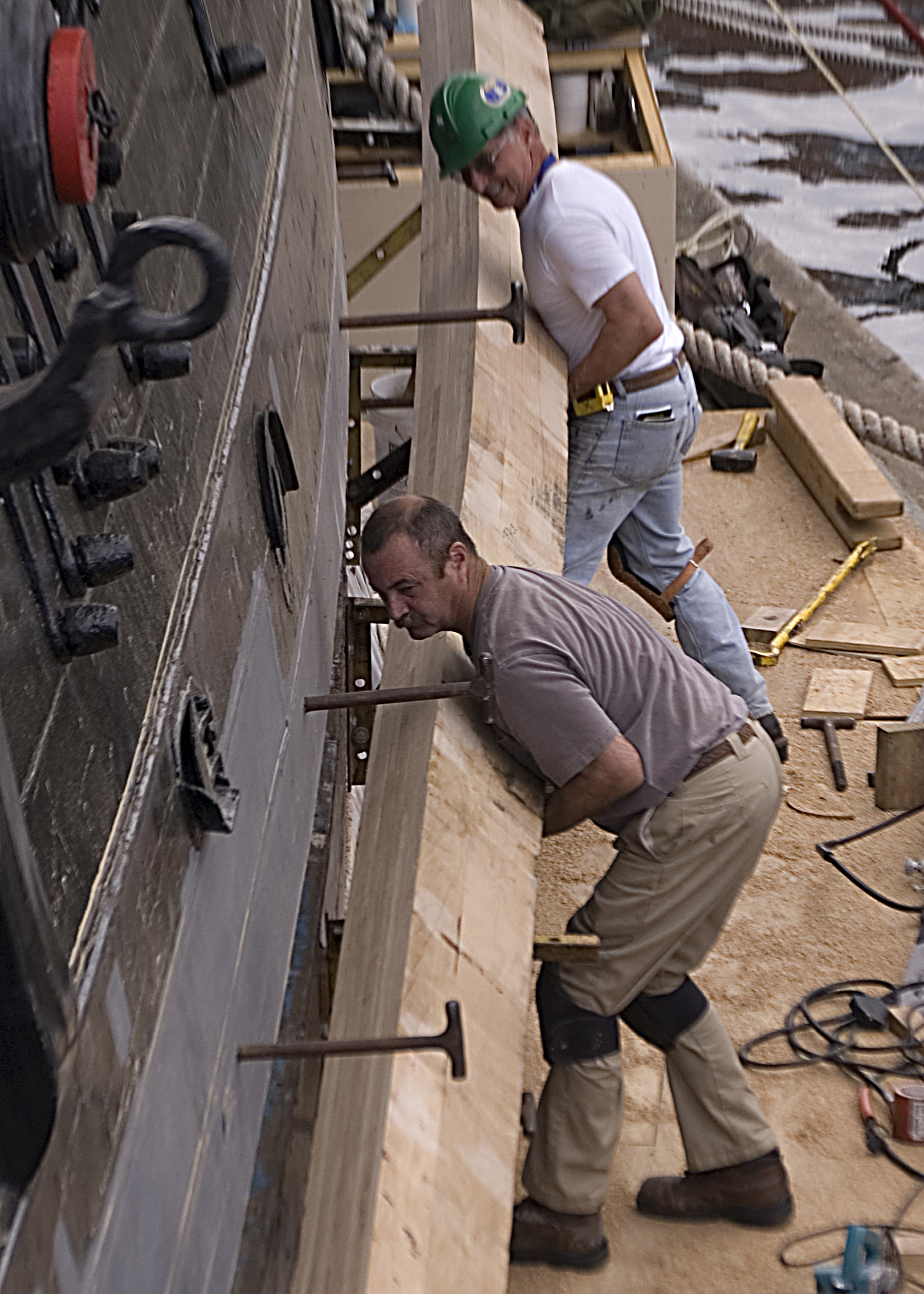 Former Master Chief Petty Officer of the Navy Steven Giordano touches the keel, which is the center backbone at the bottom of a ship.