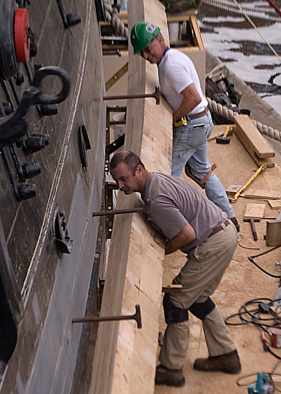 Former Master Chief Petty Officer of the Navy Steven Giordano touches the keel, which is the center backbone at the bottom of a ship.