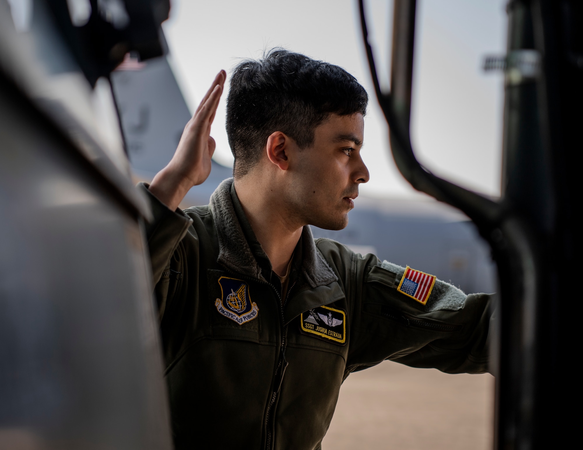 Airmen guides cargo onto aircraft