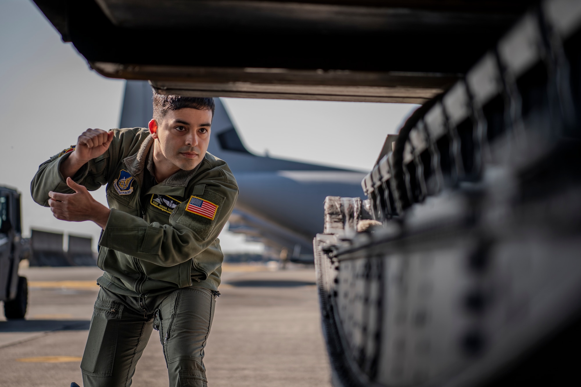 Airmen guides cargo onto aircraft