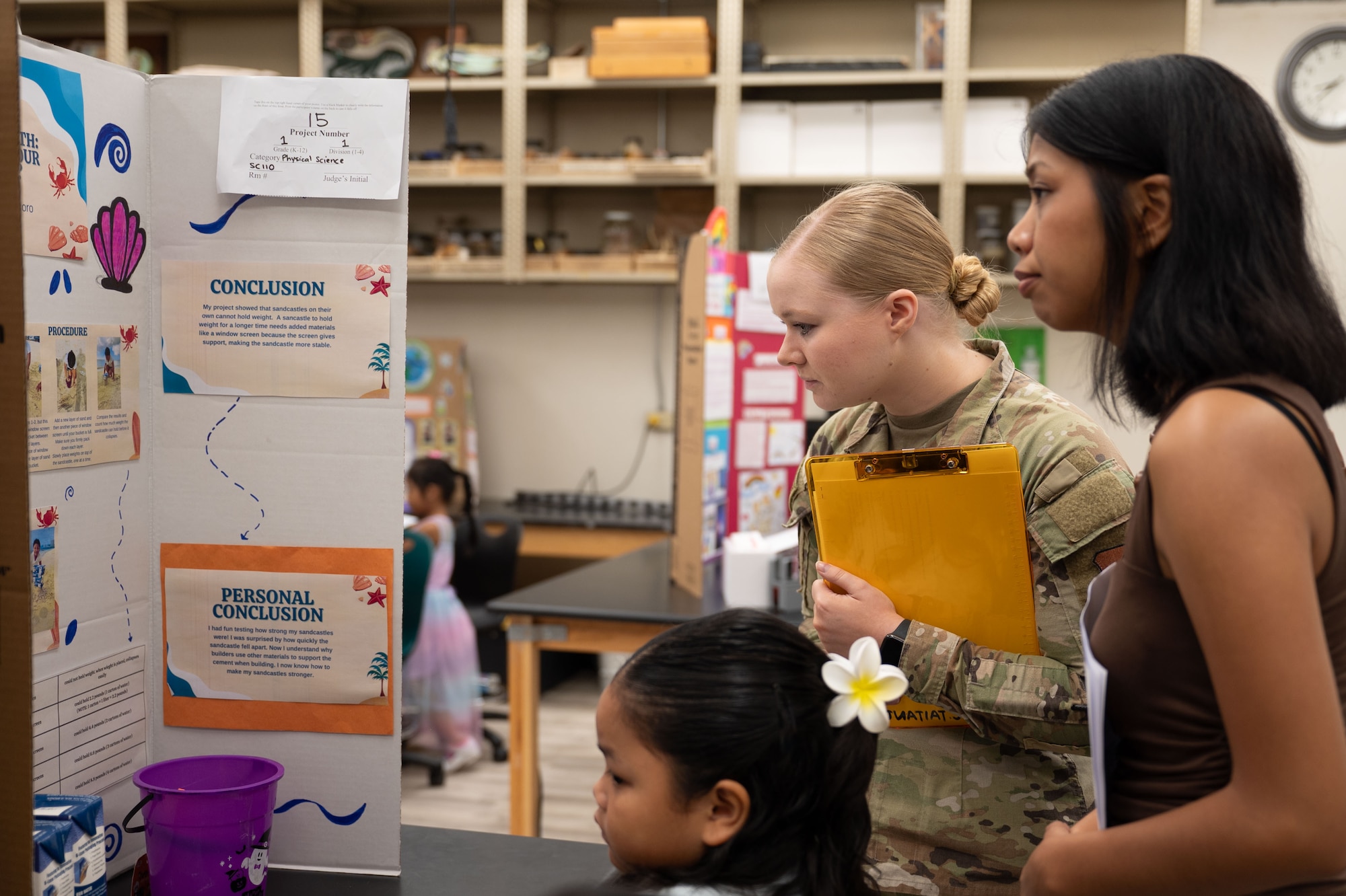 36th Medical Group, evaluate a science project during the Guam Island Wide Science Fair at the University of Guam, April 5, 2025. The purpose of the fair was to stimulate an interest in science in the Guam youth and community. (U.S. Air Force photo by Senior Airman Audree Campbell)