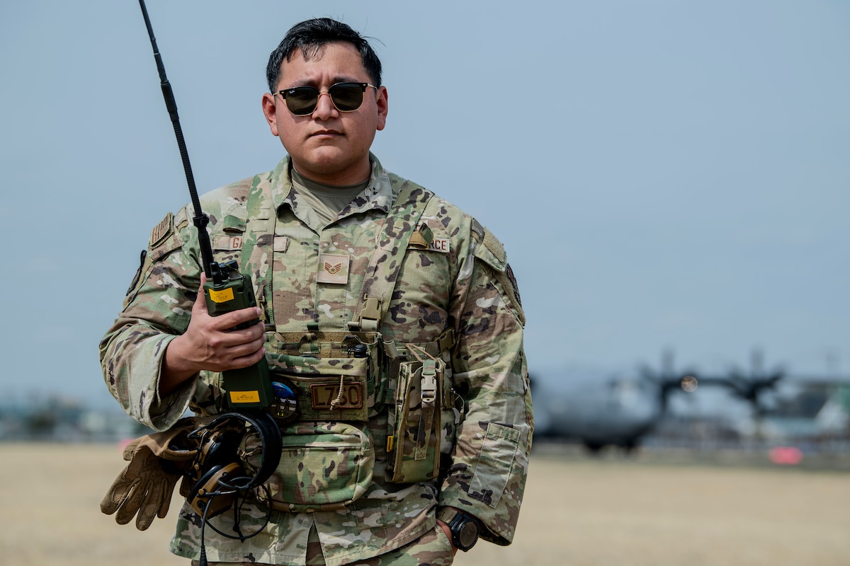 An airman poses for a photo after facilitating the landing of a C-130J Super Hercules.