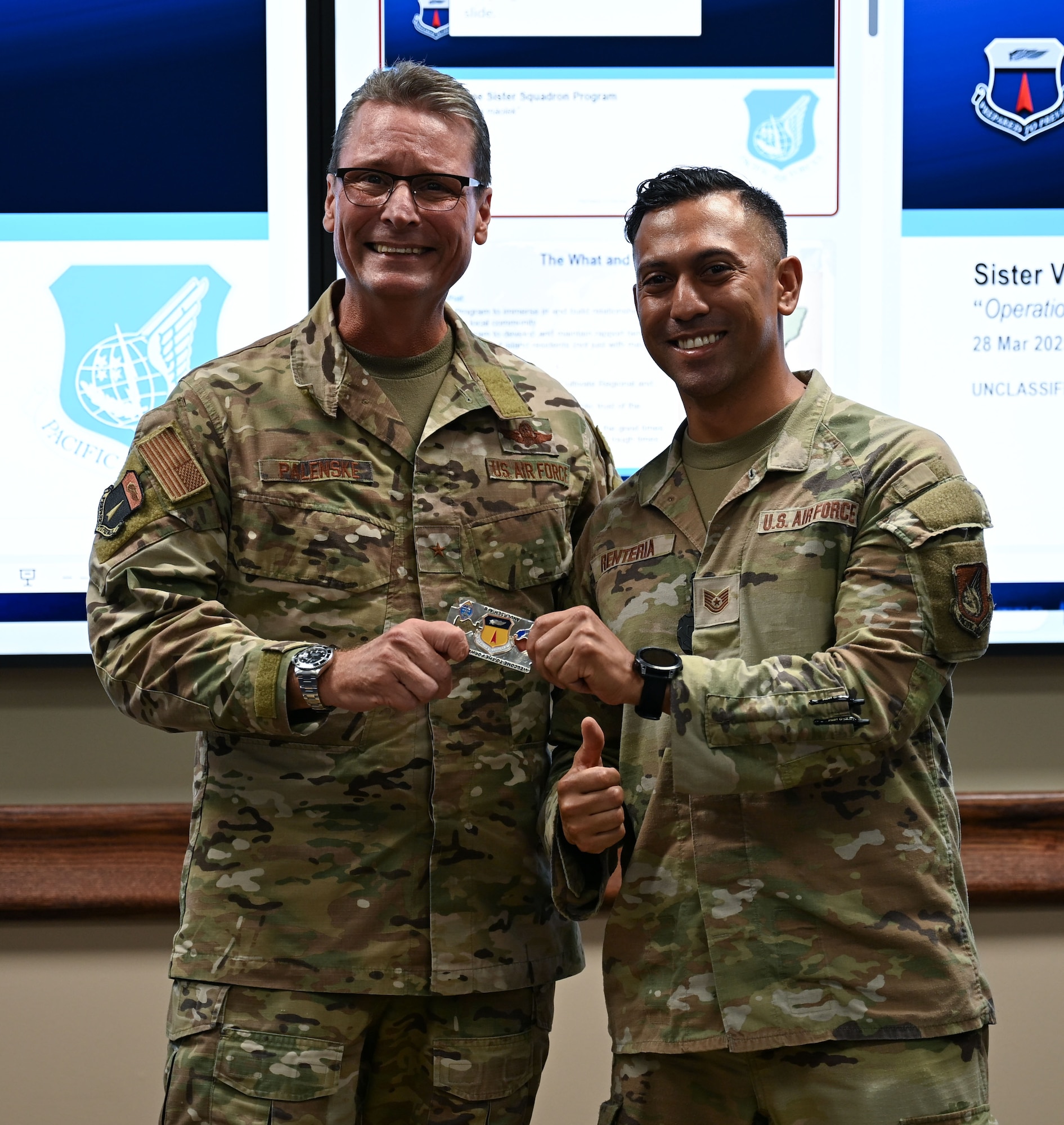 Sister Village Sister Squadron representative U.S. Air Force Tech. Sgt. Andy Renteria, 36th Medical Group TRICARE Operations and Patient Administration flight chief, gets coined by Brig. Gen. Thomas Palenske, 36th Wing commander, at Andersen Air Force Base, Guam, April 8, 2025. Renteria and other SVSS Airmen were recognized for their dedication to fostering and upholding relationships with the Mayors and community of their respective villages in Guam to provide volunteer support, mentorship, environmental clean ups and more. (U.S. Air Force photo by Senior Airman Audree Campbell)