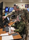 U.S. Air Force Master Sgt. Kody Zahrte, a weapons director assigned to the Wisconsin Air National Guard's 128th Air Control Squadron, assists 2nd. Lt. Gete Suurraid, a fighter controller with the Estonian Air Force March 31, 2025, during an airspace control training mission conducted with U.S. and NATO crewmembers at Volk Field Air National Guard Base in Camp Douglas, Wisconsin.