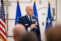 Men in uniform conduct a ceremony.